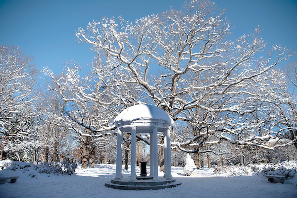 snow-covered old well and trees